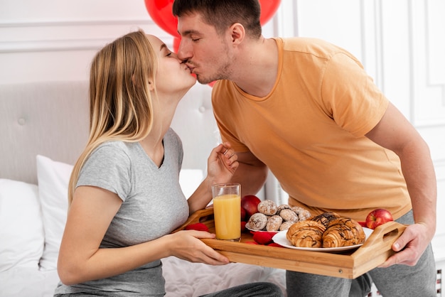 Tiro médio casal a beijar no quarto