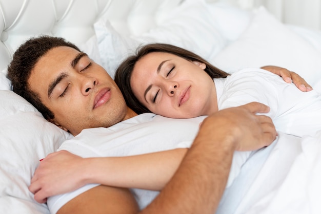 Tiro médio casal feliz dormindo juntos