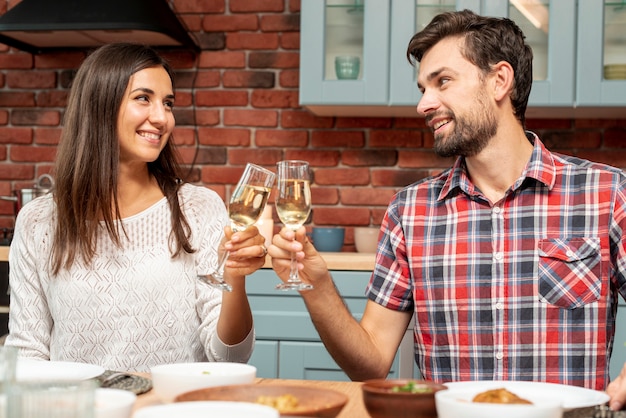 Tiro médio casal feliz fazendo um brinde