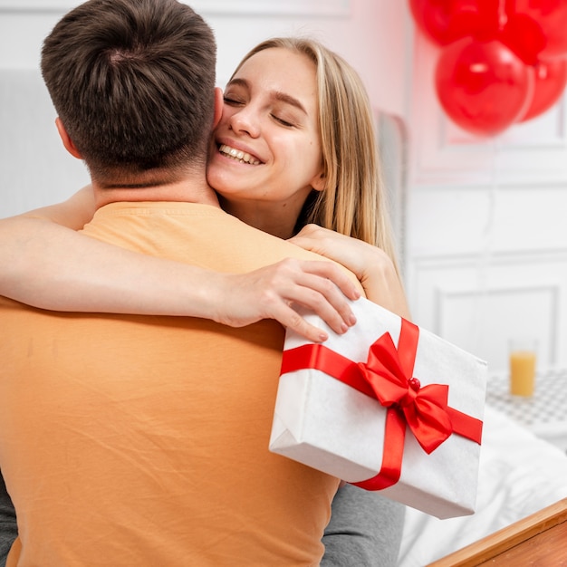 Foto grátis tiro médio casal sorridente, abraçando uns aos outros