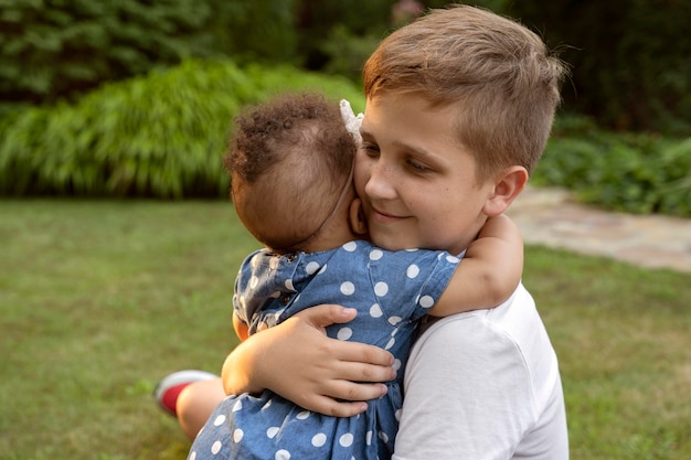 Foto grátis tiro médio criança segurando bebê