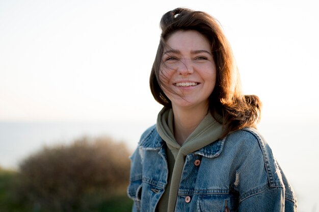 Tiro médio da menina sorrindo ao ar livre