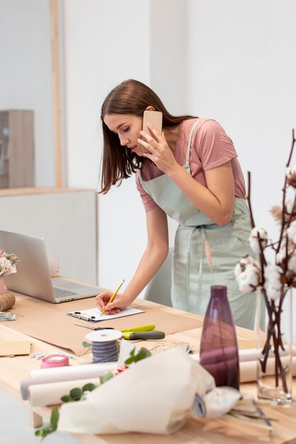 Tiro médio da mulher de negócios, falando em seu telefone móvel