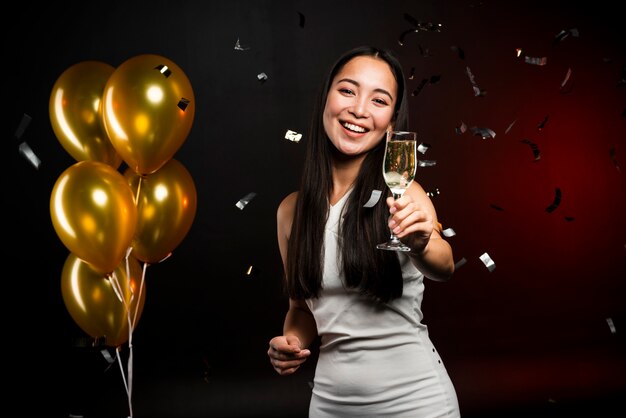 Tiro médio da mulher segurando a taça de champanhe