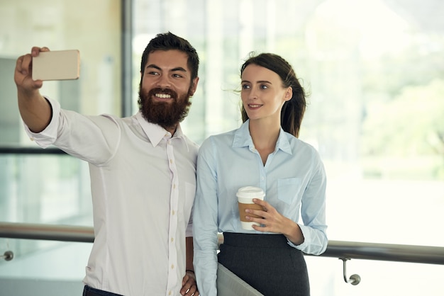 Foto grátis tiro médio de colegas tomando uma selfie