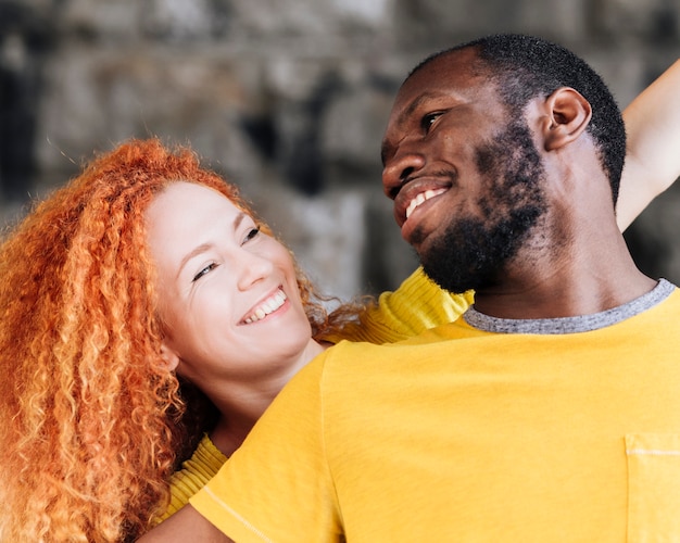 Tiro médio, de, par interracial, sorrindo, para, um ao outro