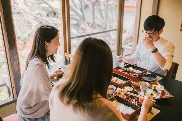 Tiro médio de pessoas sentadas à mesa juntas