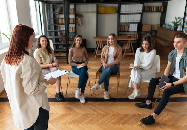 Foto grátis tiro médio de pessoas sentadas em cadeiras