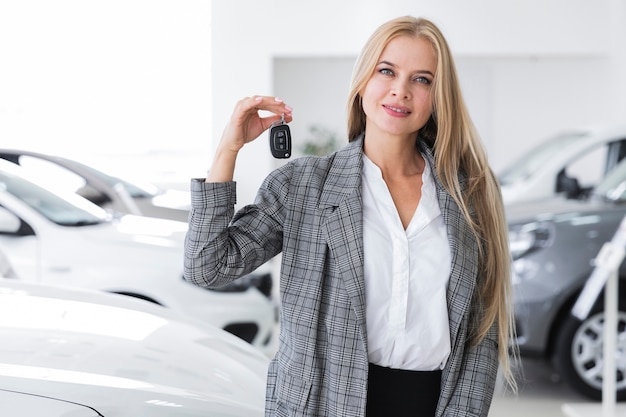 Tiro médio, de, um, loiro, mulher segura, um, tecla carro