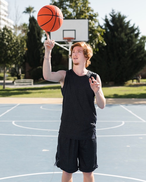 Tiro médio do garoto brincando com bola de basquete