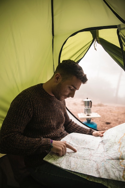 Foto grátis tiro médio homem com mapa na barraca