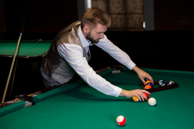 Foto grátis tiro médio homem elegante organizar bolas de bilhar