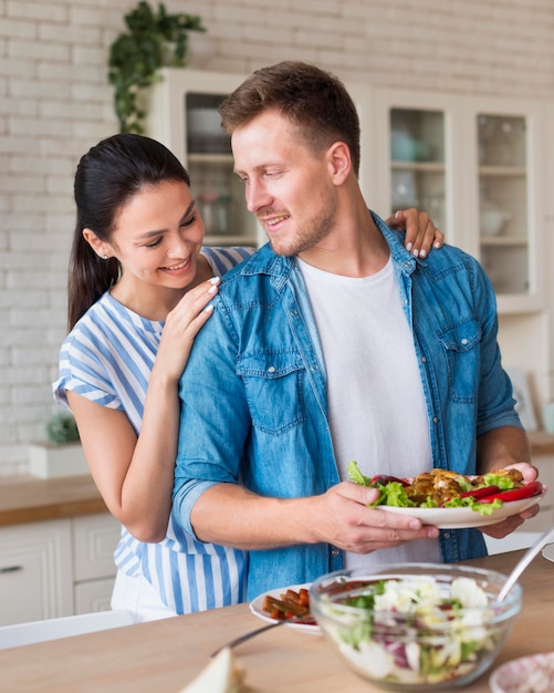 Tiro médio homem segurando o prato de comida