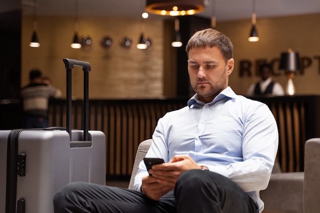 Foto grátis tiro médio homem segurando smartphone