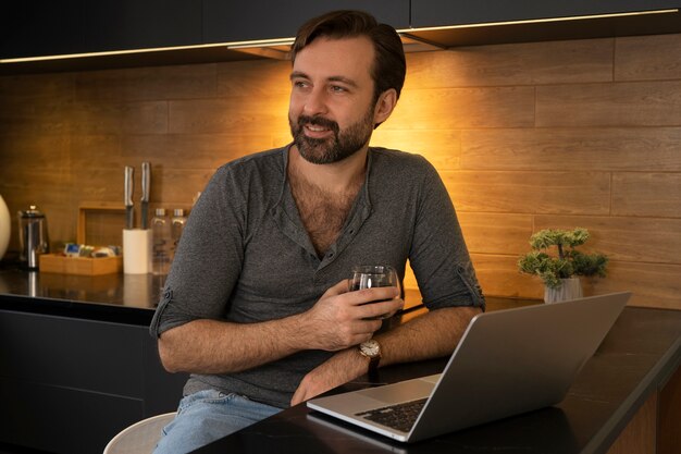 Tiro médio homem trabalhando no laptop