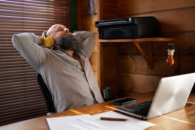 Tiro médio homem trabalhando no laptop