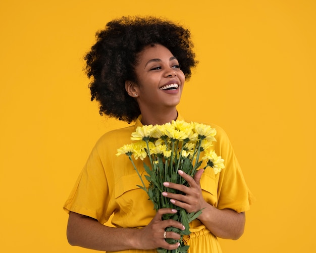 Tiro médio jovem posando com flores