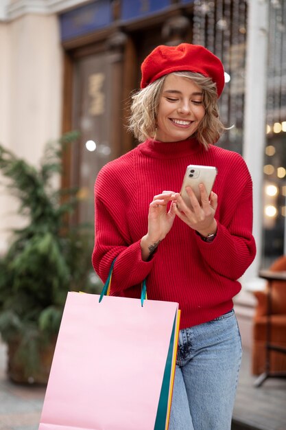 Tiro médio jovem segurando smartphone