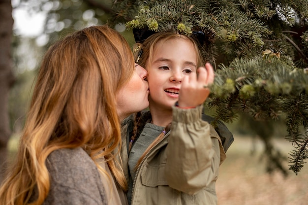 Tiro médio mãe beijando filha