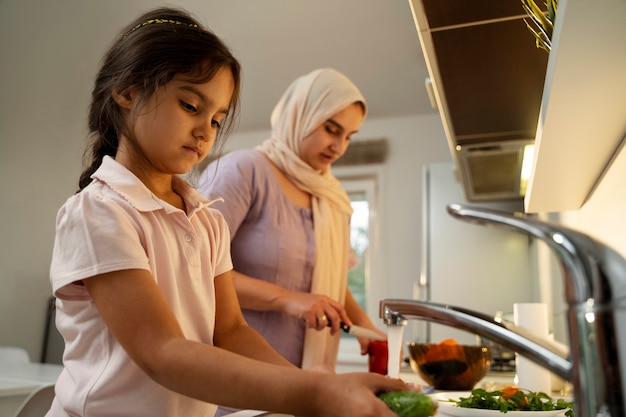 Tiro médio mãe e menina cozinhando