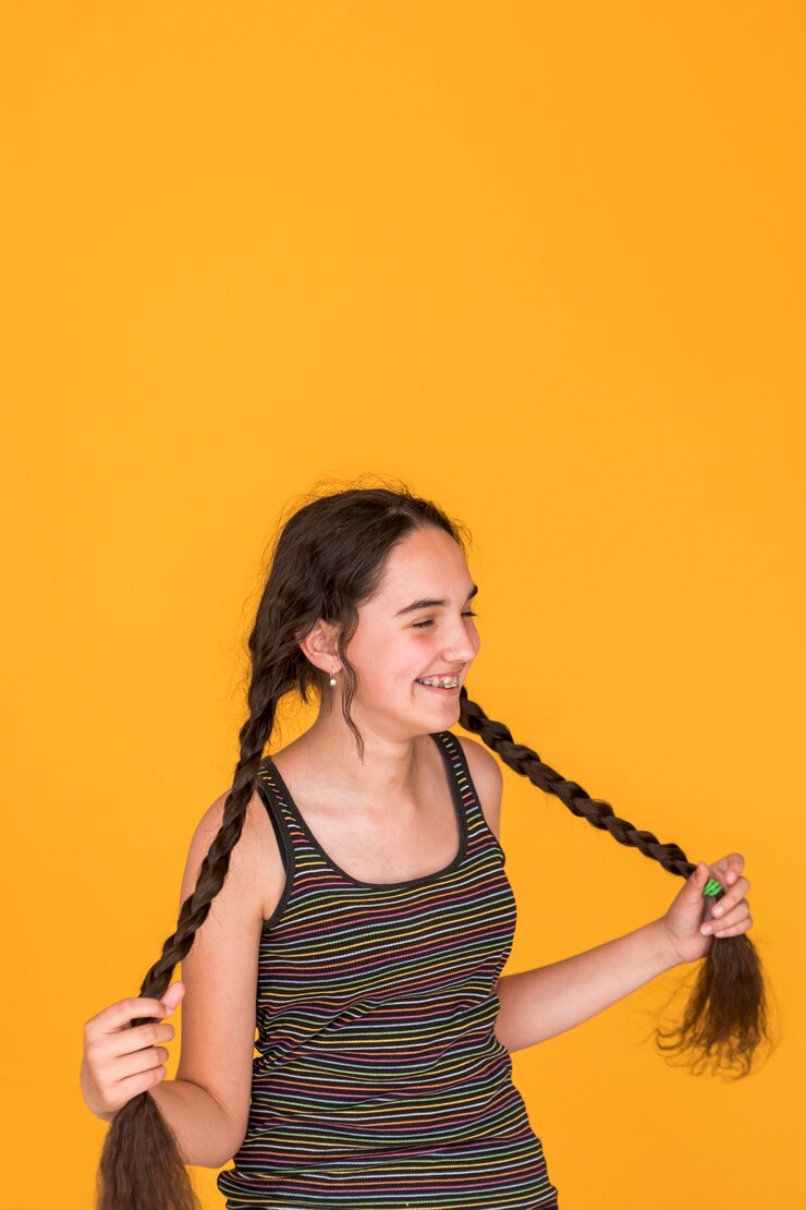 Foto grátis tiro médio, menina, tocando, com, dela, tranças