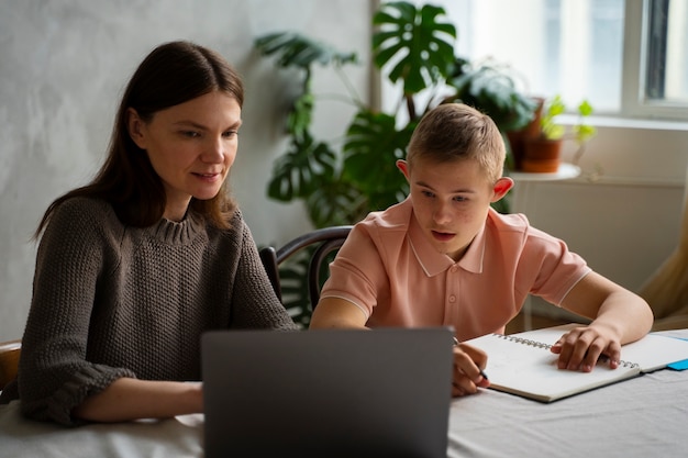 Tiro médio menino e mulher com laptop