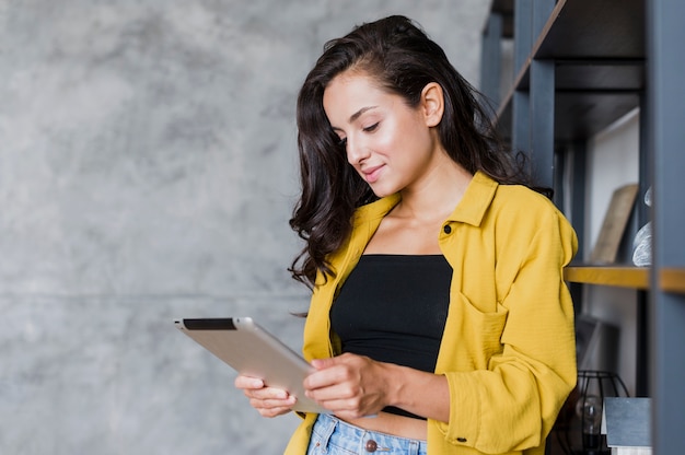 Foto grátis tiro médio morena menina olhando para tablet