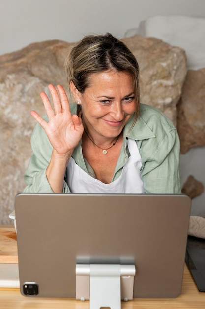 Tiro médio mulher acenando para tablet