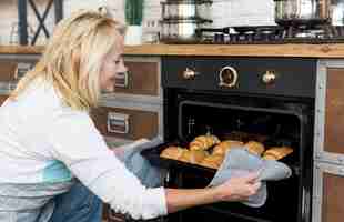 Foto grátis tiro médio mulher feliz croissants de cozimento