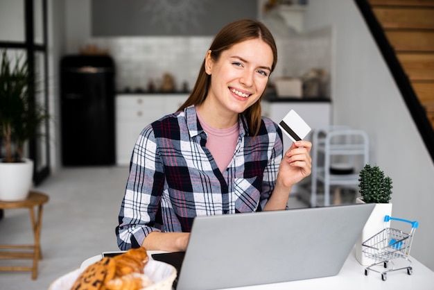 Foto grátis tiro médio mulher feliz mostrando cartão de crédito