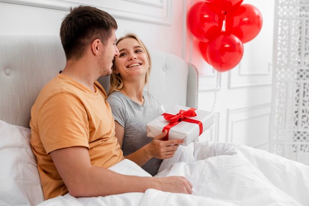 Tiro médio mulher feliz segurando um presente