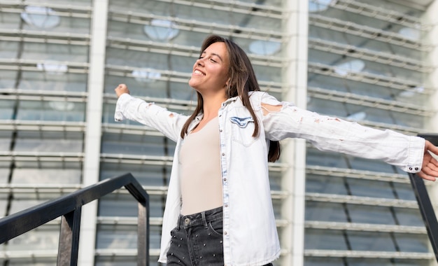 Foto grátis tiro médio, mulher jovem, sorrindo, ao ar livre