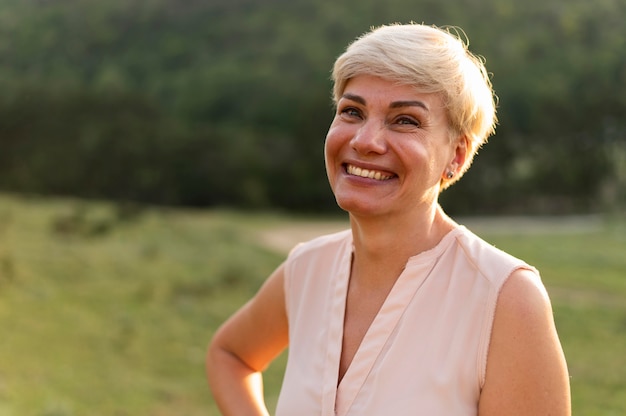 Foto grátis tiro médio mulher sorridente ao ar livre