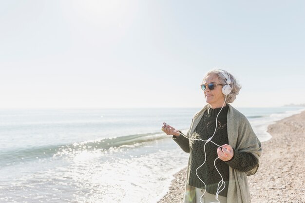 Tiro médio mulher sorridente com fones de ouvido ao ar livre