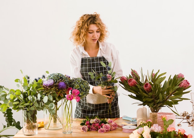 Foto grátis tiro médio mulher trabalhando na loja de flores