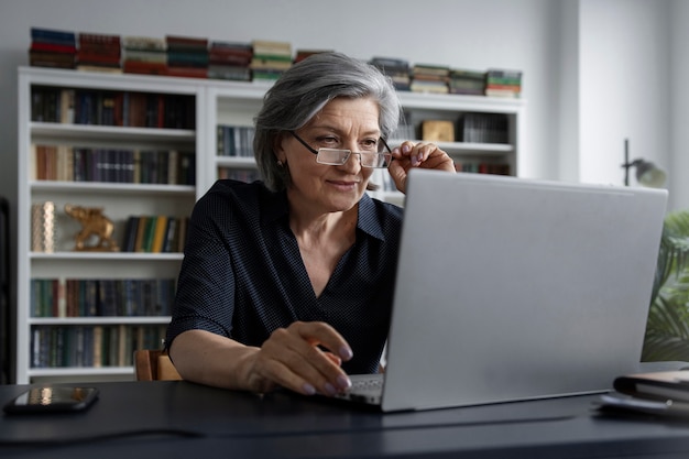 Tiro médio mulher trabalhando no laptop