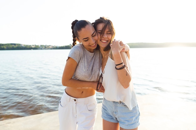 Tiro médio, mulheres, abraçando, perto, um, lago