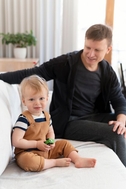 Tiro médio, pai e filho no sofá