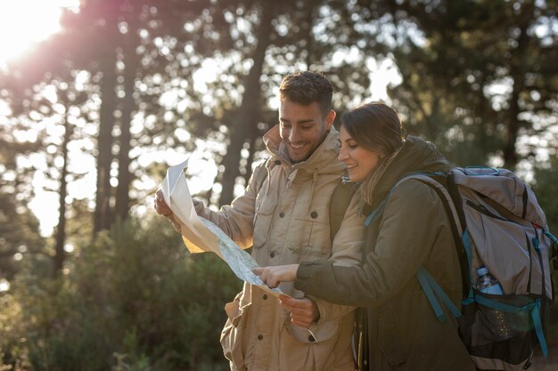 Foto grátis tiro médio pessoas com mapa na floresta