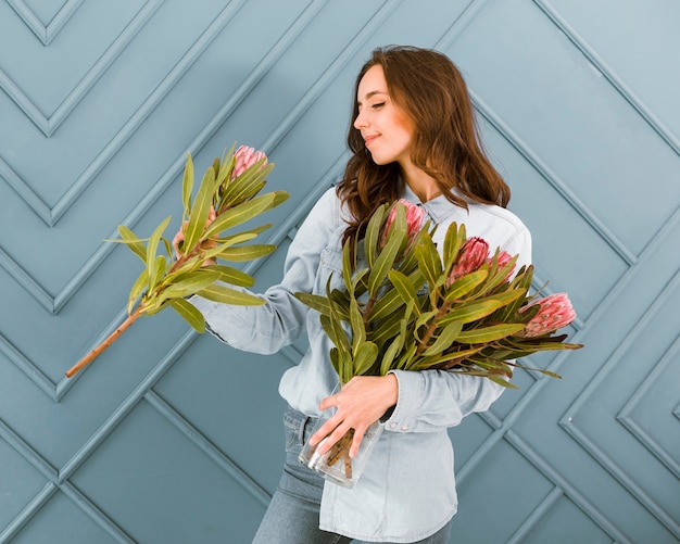 Foto grátis tiro médio sorridente mulher segurando buquê de flores