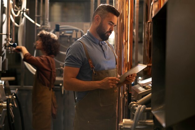 Tiro médio trabalhando na fábrica de cerveja