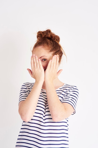 Foto grátis tiro retrato de mulher tímida cobrindo o rosto com as mãos