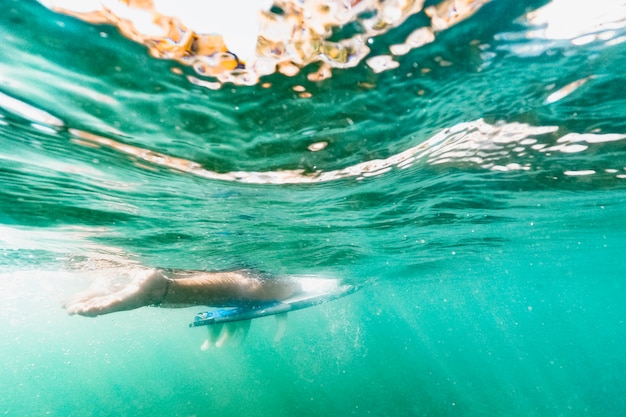 Tiro subaquático de mulher com prancha de surf