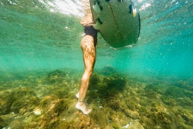 Tiro subaquático de mulher com prancha de surf