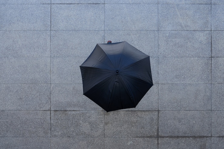 Foto grátis tiro superior da pessoa irreconhecível em pé sob o guarda-chuva na calçada