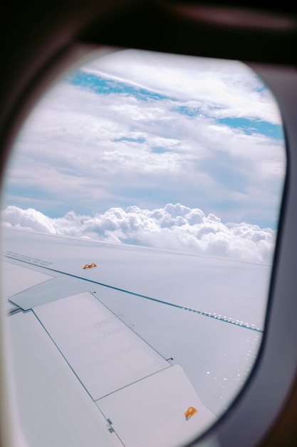 Foto grátis tiro vertical das nuvens capturadas na janela de um avião