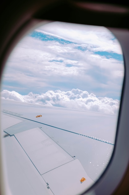 Tiro vertical das nuvens capturadas na janela de um avião