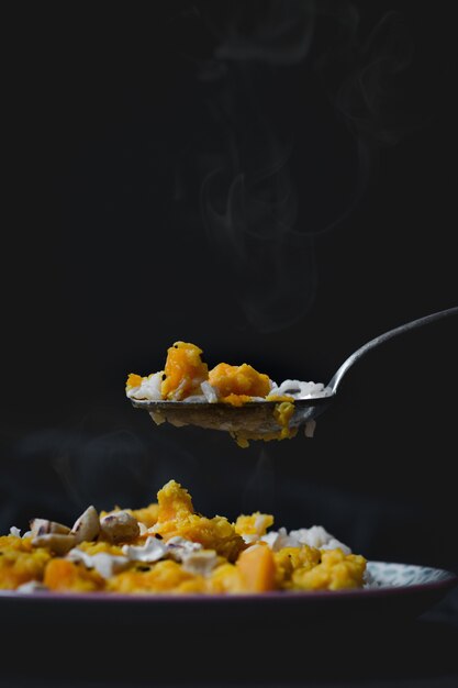 Tiro vertical de alto ângulo de um delicioso prato quente com arroz, frango e molho amarelo