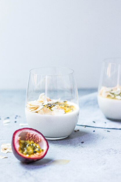 Tiro vertical de bebida de coco e maracujá em uma superfície branca