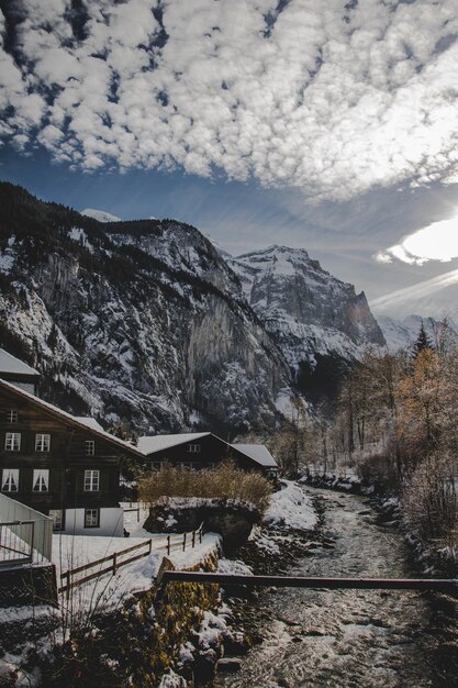 Tiro vertical de cabines e edifícios em uma área de resort cercada por colinas rochosas e neve